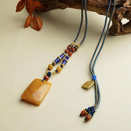 Handcrafted Tibetan Buddhist pendant featuring Xiangyang amber and lapis lazuli.