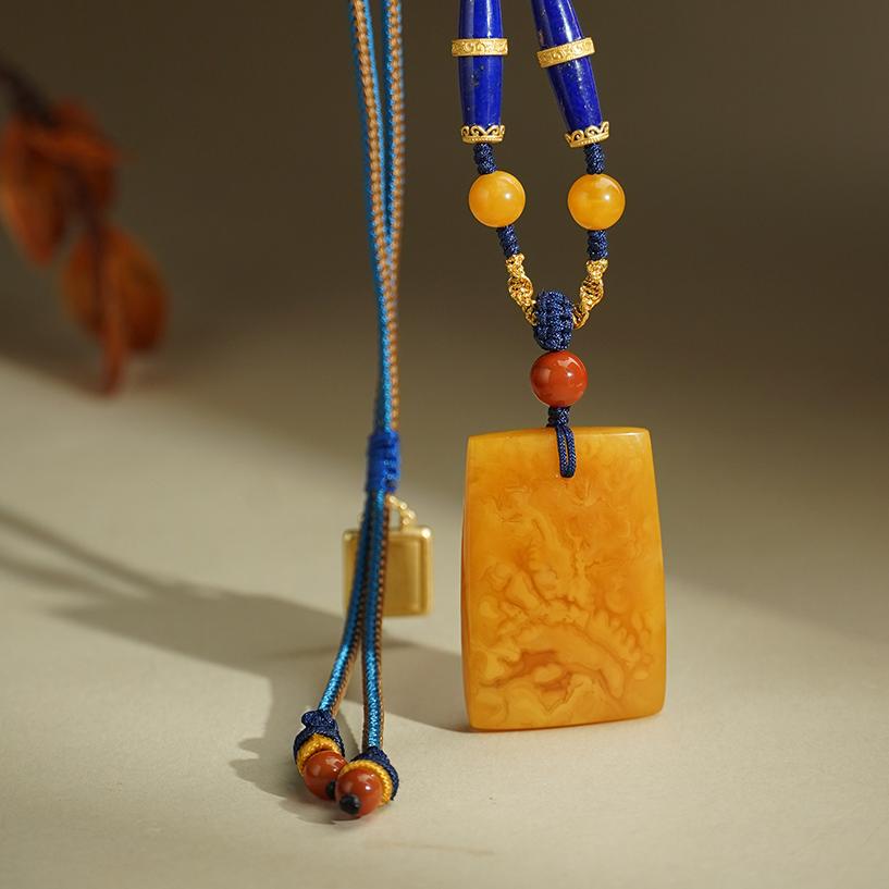 Sterling silver inlaid lapis lazuli pendant with warm amber tones.