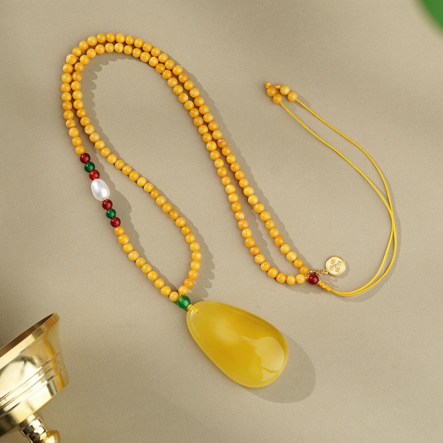 Handmade honey amber necklace inspired by Tibetan jewelry tradition, crafted with pearls and agate for inner peace.