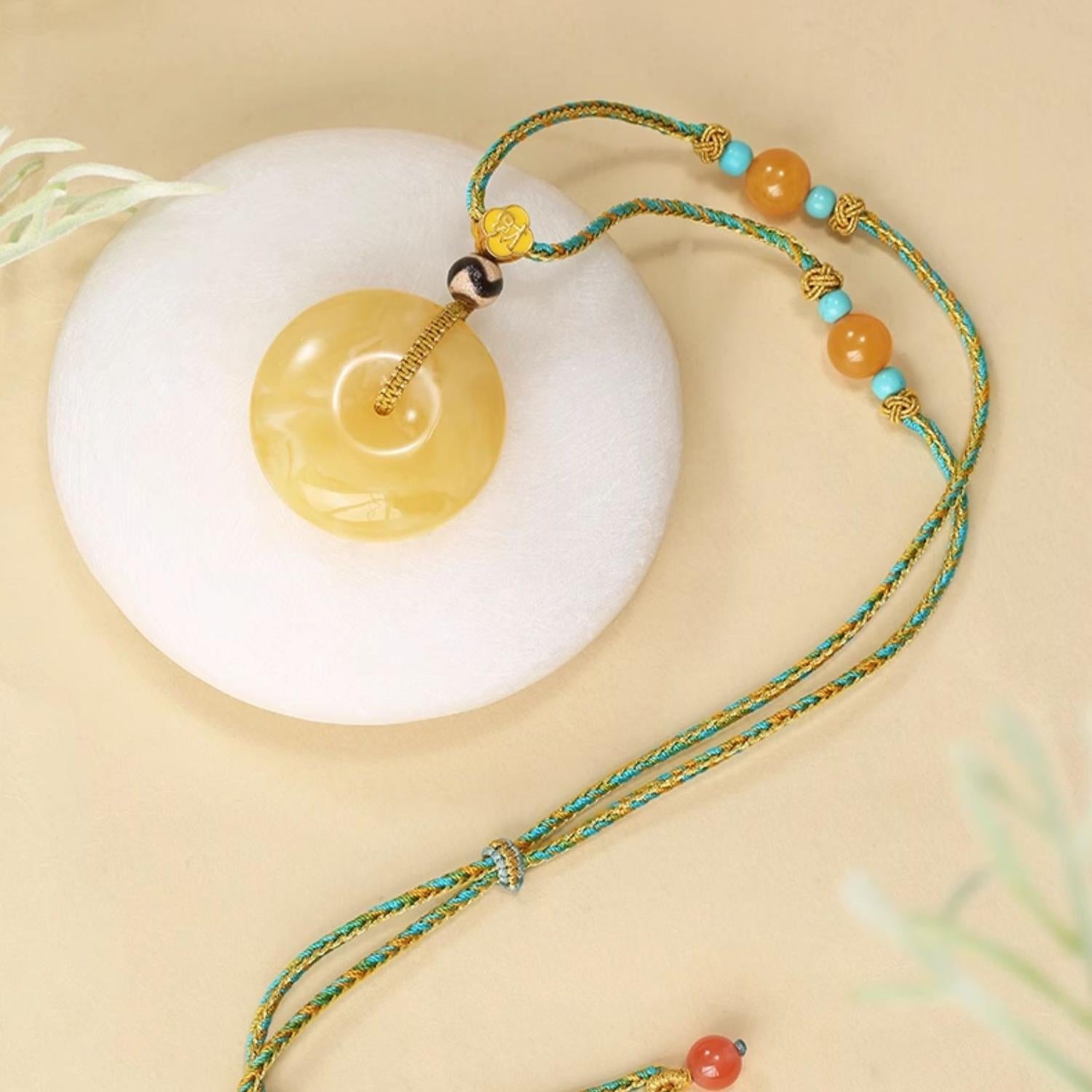 Handcrafted Tibetan Buddhist amber and tiger tooth Dzi pendant necklace, symbol of fortune and harmony