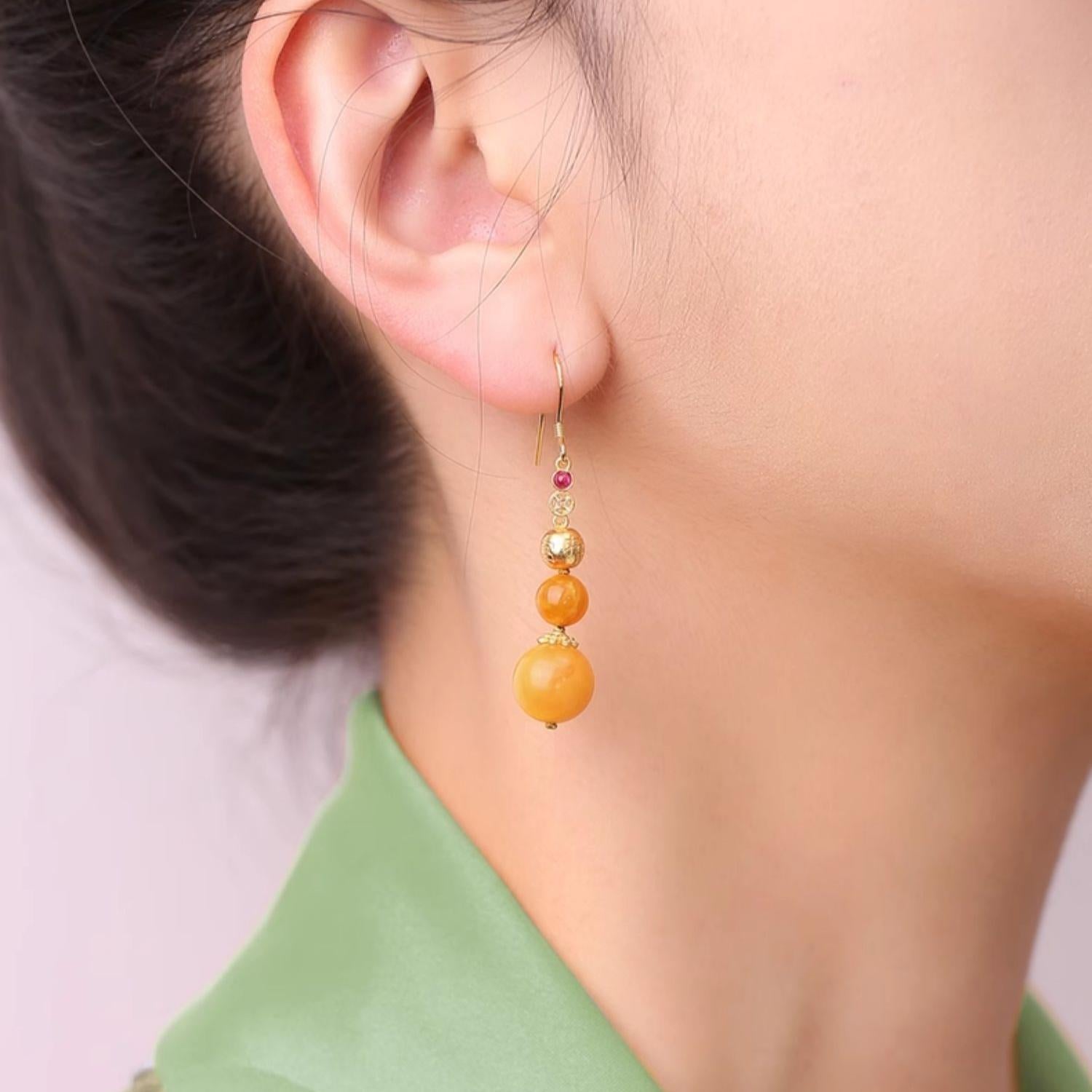 "Tibetan Buddhist-inspired amber earrings with zircon, representing balance and spiritual growth."