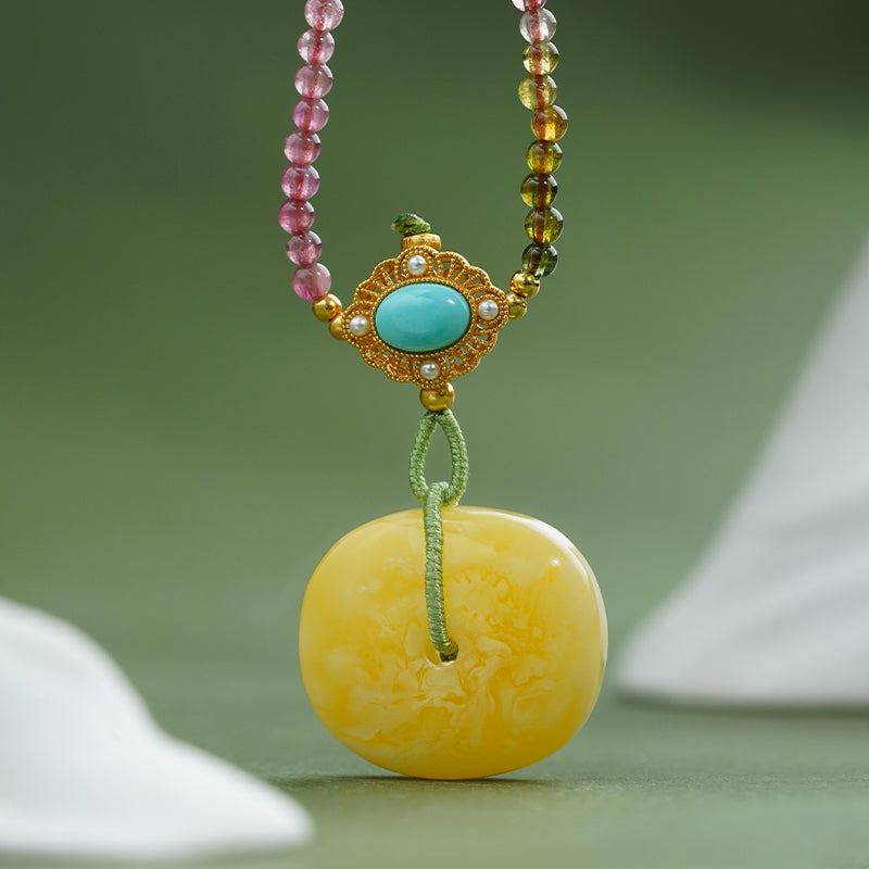 Elegant Buddhist jewelry piece featuring amber, tourmaline, and turquoise for balance and inner light.