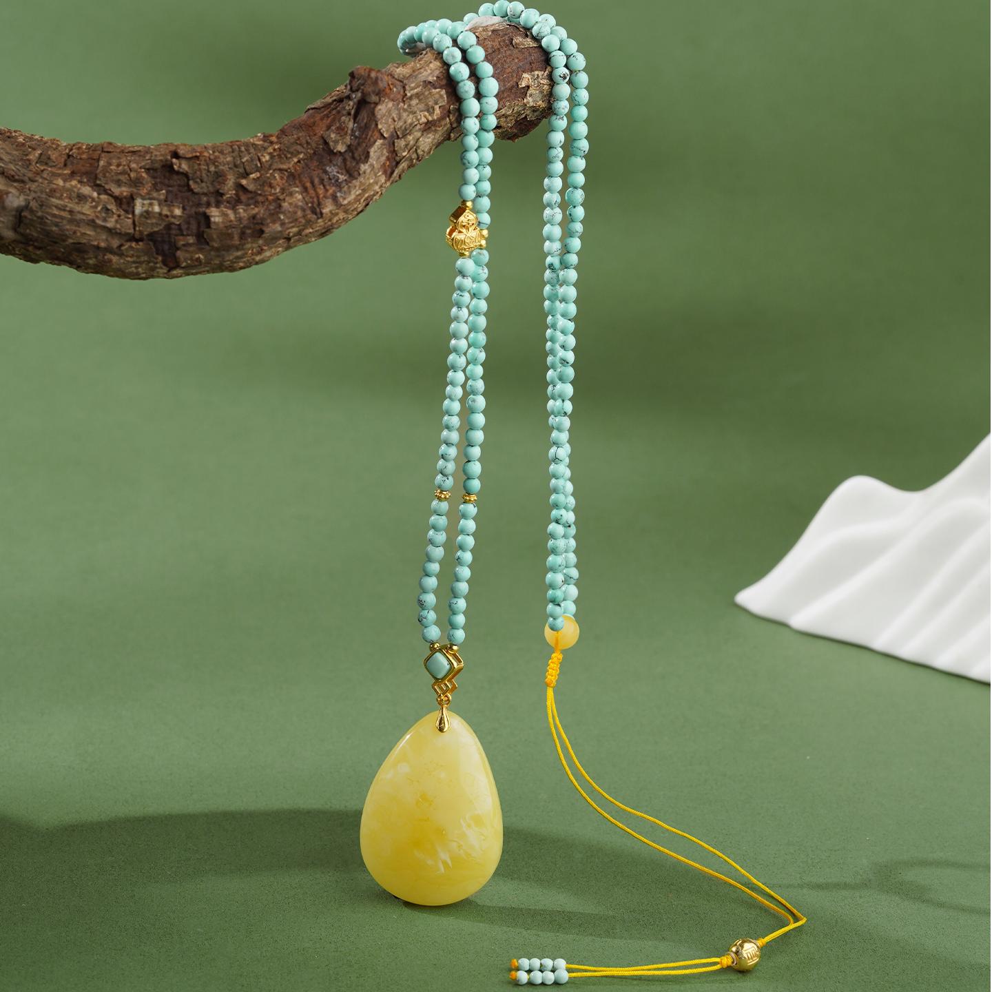 Tibetan Buddhist amber and turquoise pendant, symbolizing serenity and protection, handmade by artisans.