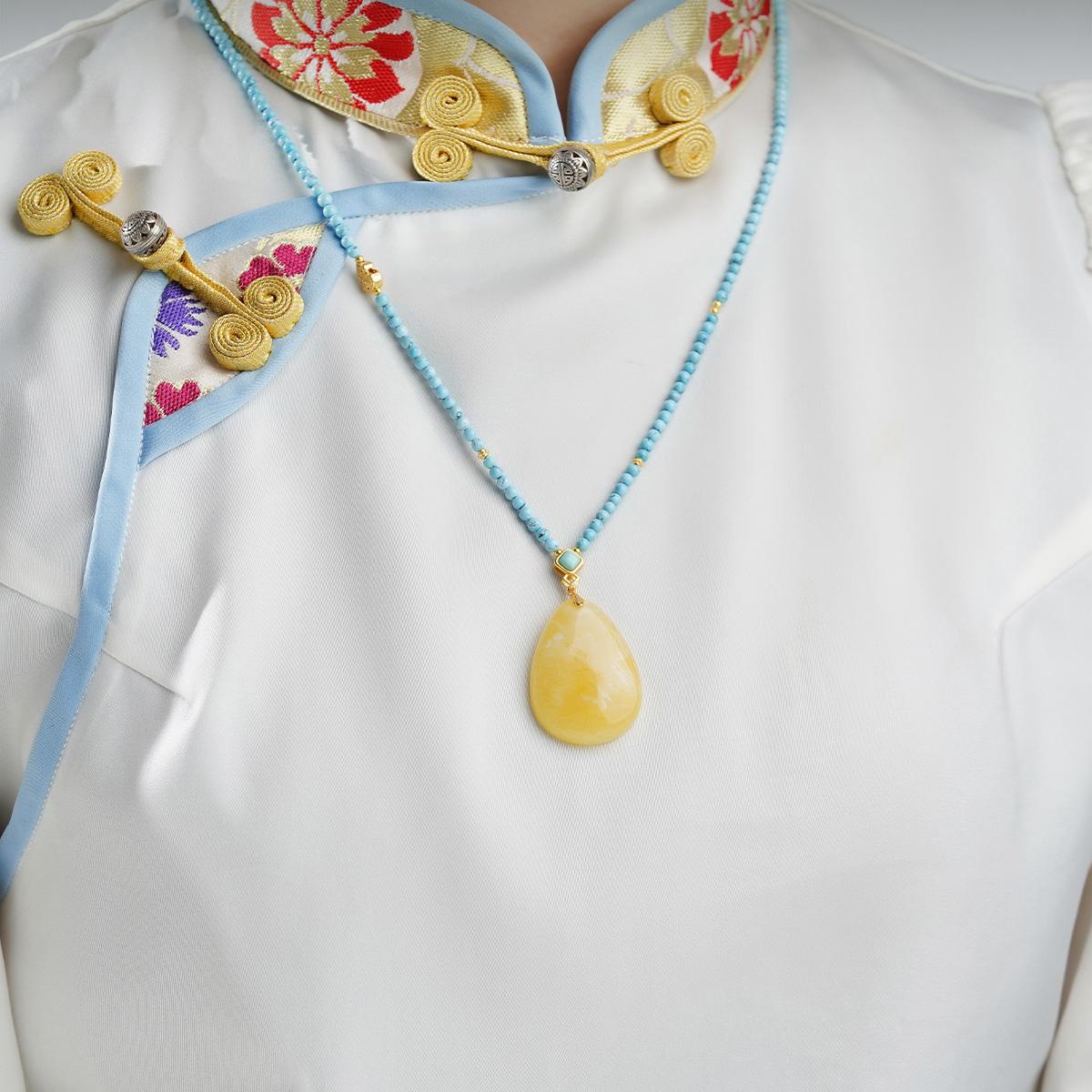 Tibetan Buddhist pendant with amber, silver, and tourmaline beads, ideal for spiritual balance.