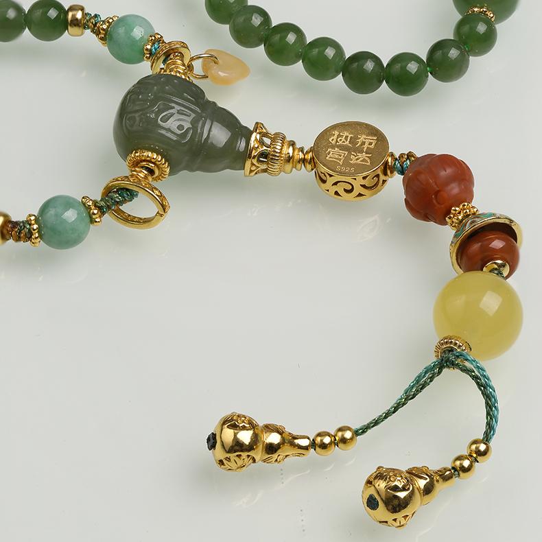 Artisan Tibetan Buddhist jewelry crafted with jade, jadeite, amber, and silver beads, symbolizing harmony and wisdom.