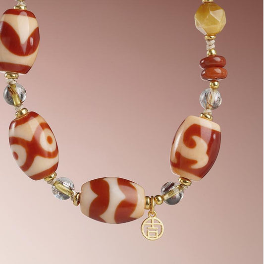 Tibetan Buddhist necklace featuring red agate, cinnabar, and crystal beads symbolizing strength and vitality.