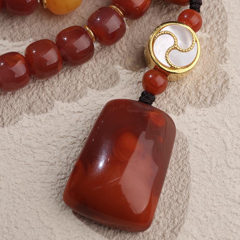 Handcrafted Buddhist 108-bead necklace featuring silver spacers, South Red Agate, and warm amber accents.