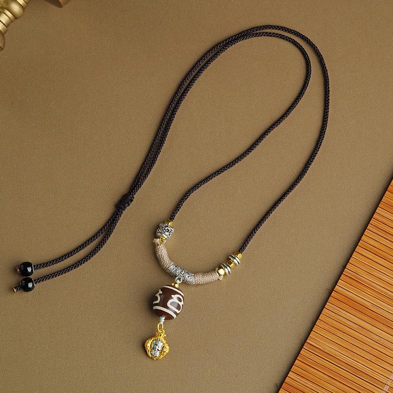 Authentic Tibetan Buddhist Dzi Bead Pendant made from genuine agate with a detailed copper setting.