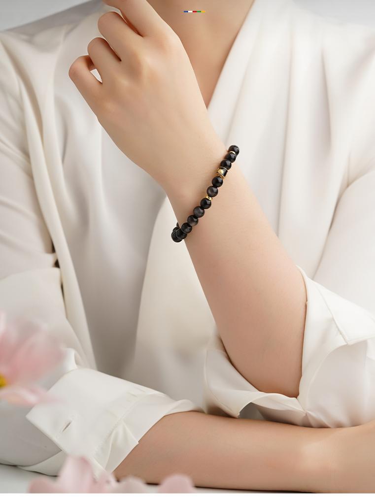 Tibetan-Buddhist Xingye Bracelet with silver obsidian beads and copper charm artistry for spiritual jewelry.