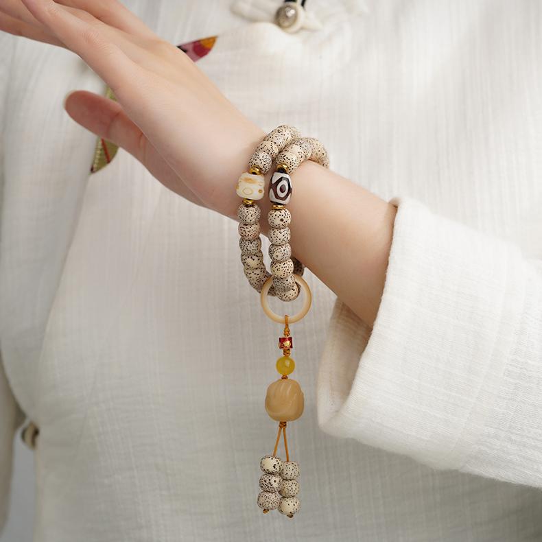 Tibetan handmade Bodhi bracelet with olive nut carving and spiritual thangka-inspired detailing.