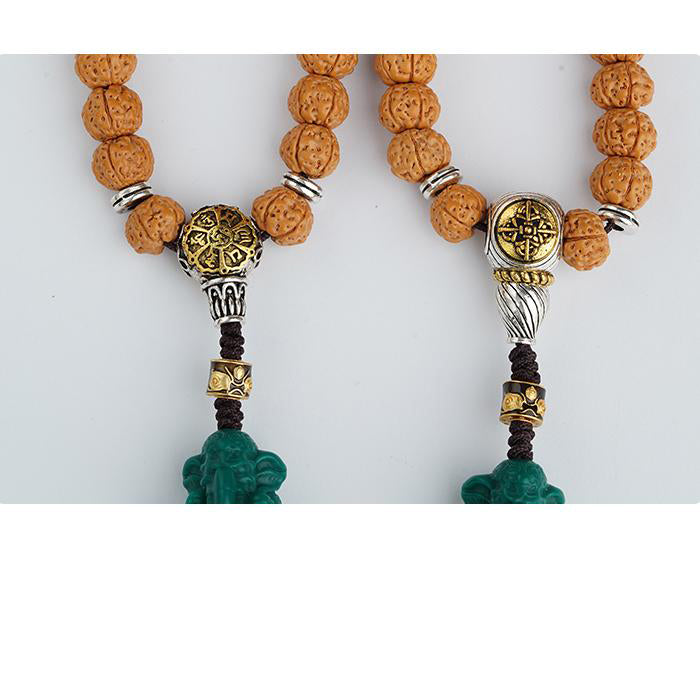 Artisan Tibetan vajra Bodhi bead strand featuring carved glass centerpiece.