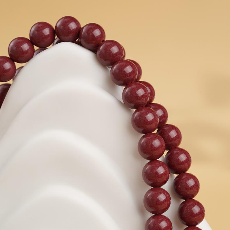 Tibetan-Buddhist mala necklace with cinnabar carving and glass guru bead symbolizing compassion and enlightenment
