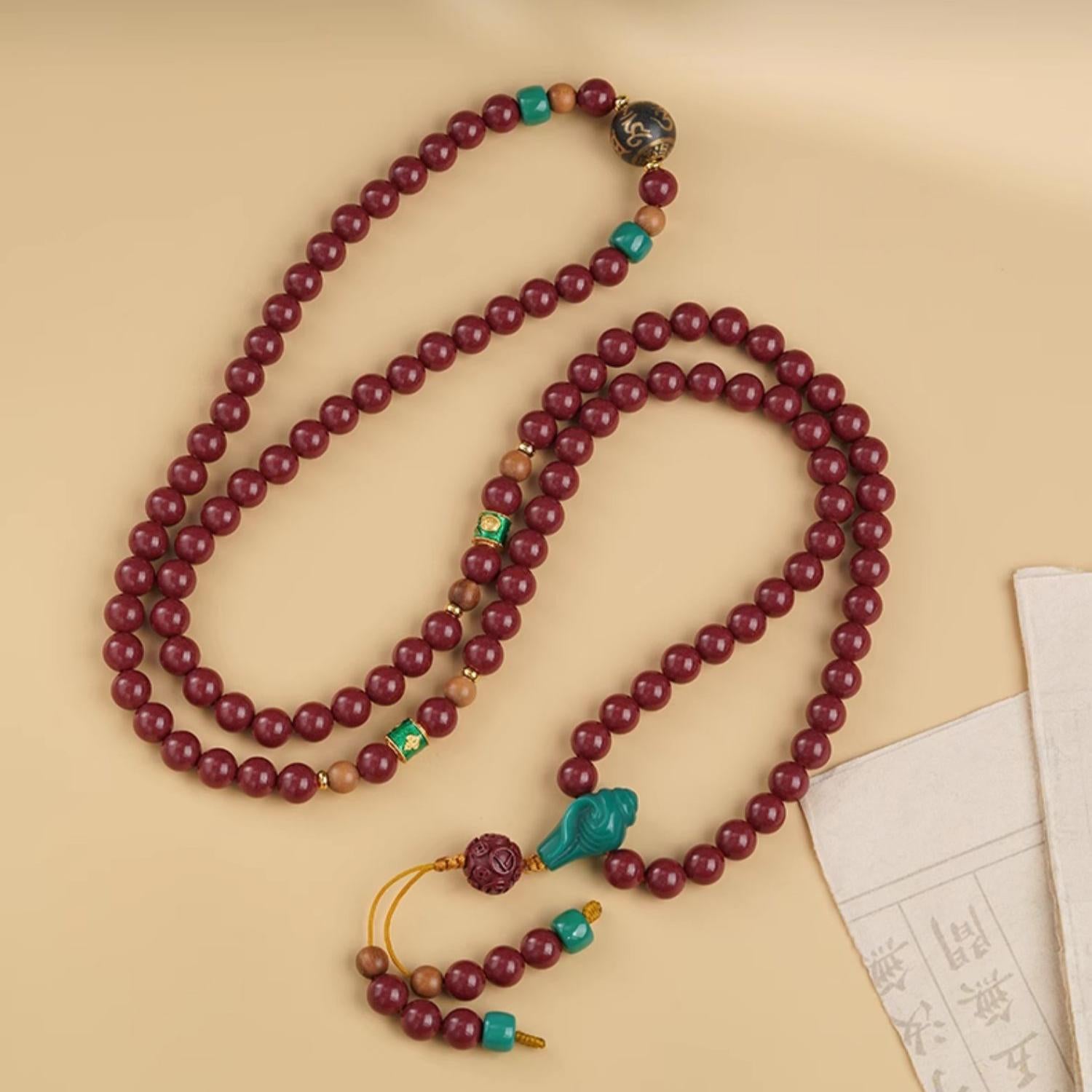 Handcrafted Tibetan-Buddhist cinnabar mala necklace with glass and sandalwood, representing peace, protection, and balance