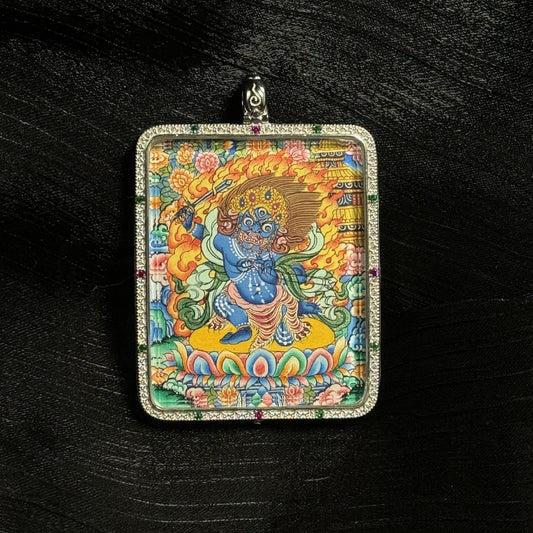 The Acala with Eight Guardians and Mandala Thangka pendant displayed as a sacred amulet for wisdom and protection, embodying Tibetan Buddhist tradition.

