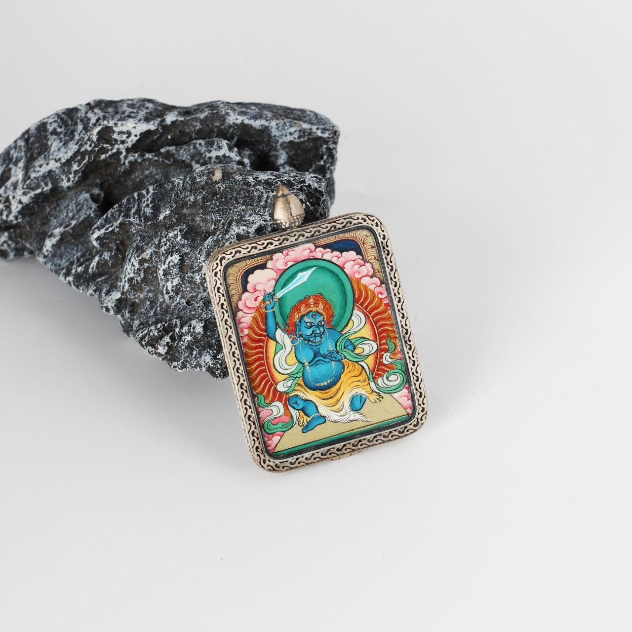  A 2.5x3.5cm hand-painted Karma Kagyu Acala Thangka pendant featuring the Immovable Wisdom King, encased in titanium steel, representing protection and subjugation of obstacles in Tibetan Buddhist tradition.

