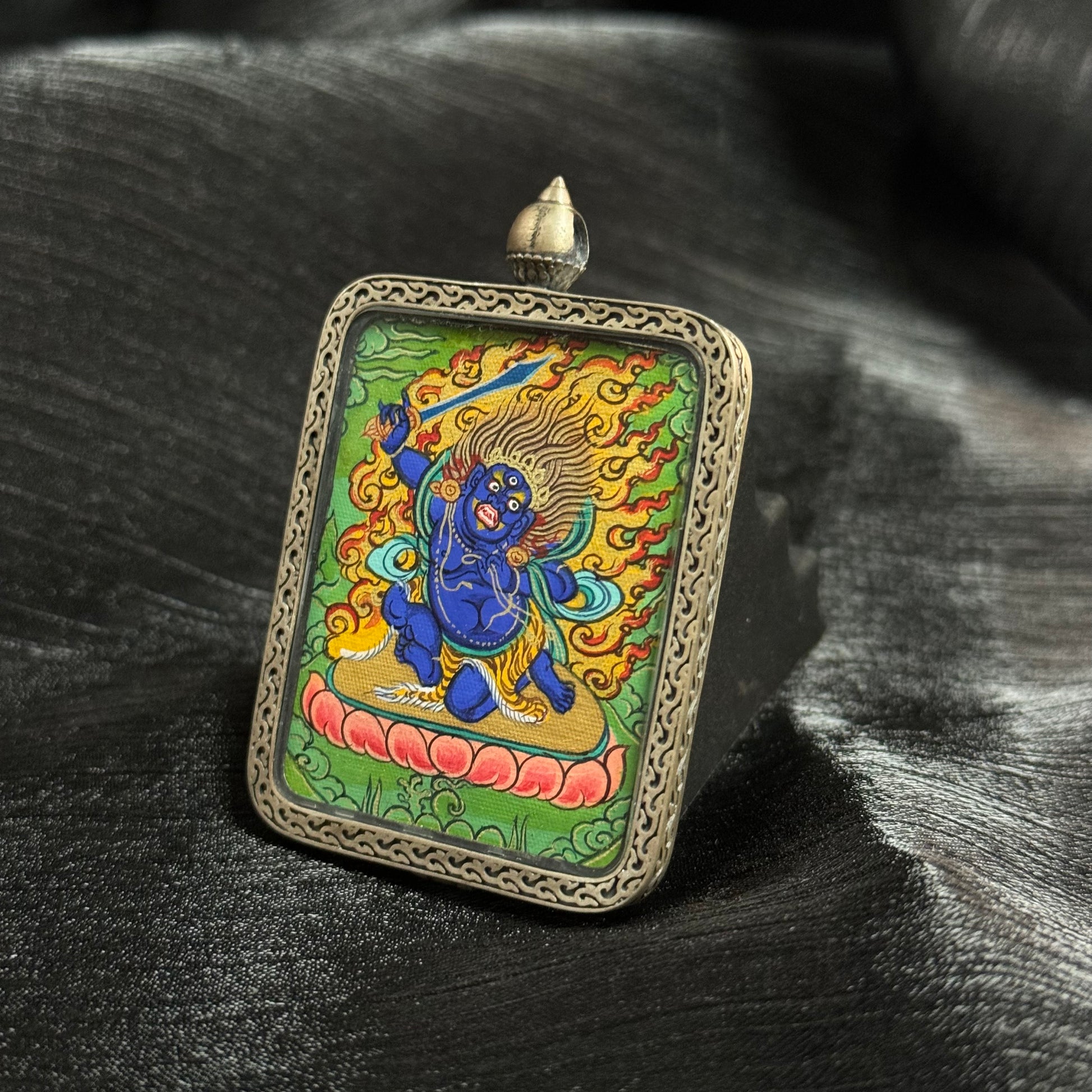 A 3.5x4.5cm hand-painted Rekong Cuiying series Acala (Acharuta) Thangka pendant featuring the first of the Five Great Wisdom Kings, representing awakening and protection in Buddhist tradition.


