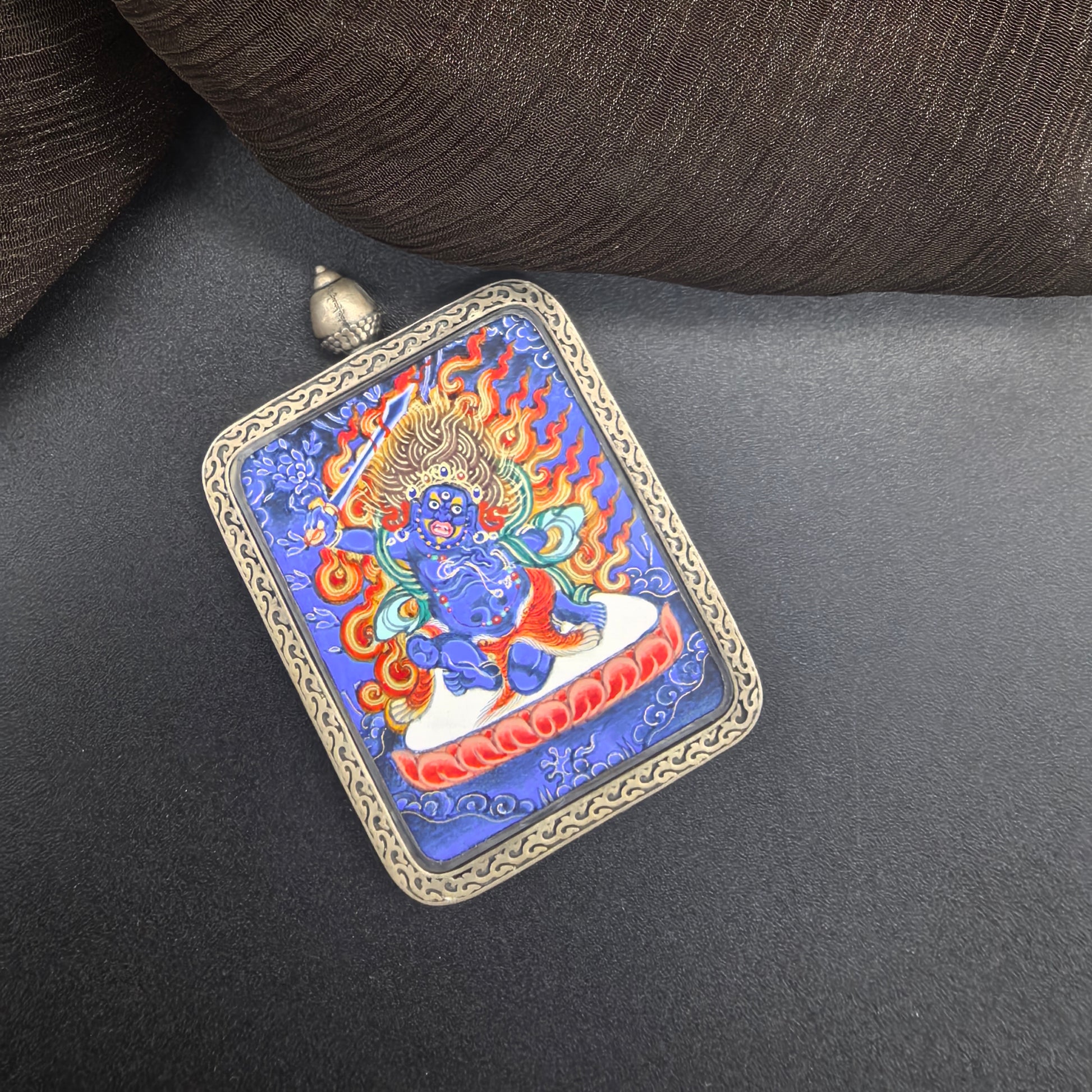  A 3.5x4.5cm hand-painted Rekong Blue Thangka Acala (不动明王) Thangka pendant with 925 silver featuring the Immovable One and chief of the five wisdom kings, representing discipline and protection in Buddhist tradition.
