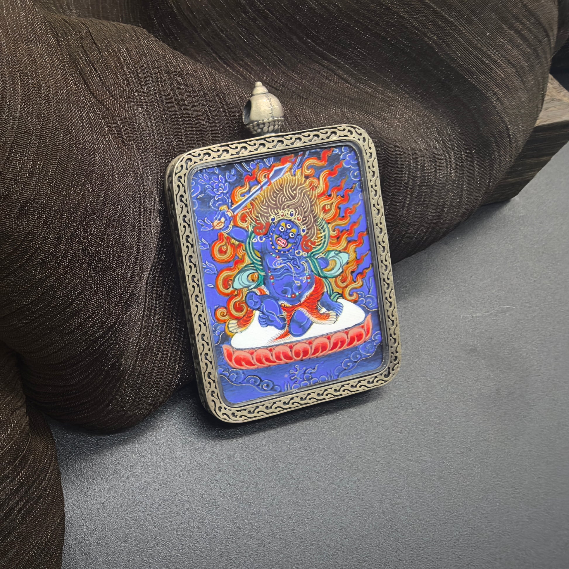 The Rekong Blue Thangka Acala pendant with 925 silver displayed as a sacred amulet for discipline and protection, embodying Buddhist tradition.
