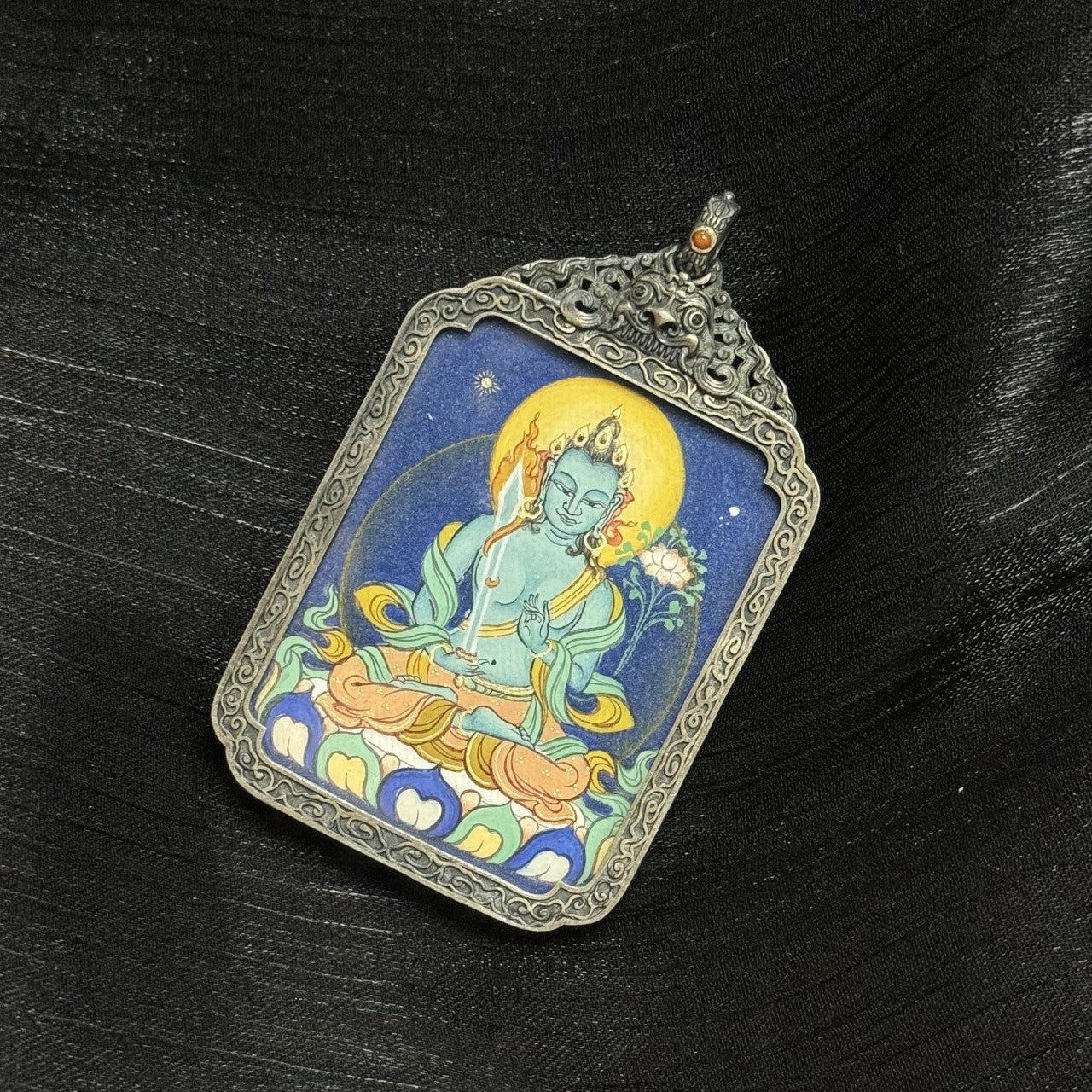 Detailed view of the antique silver-tone casing for the Akasagarbha Thangka pendant, symbolising protection and elegance in Tibetan Buddhist tradition.
