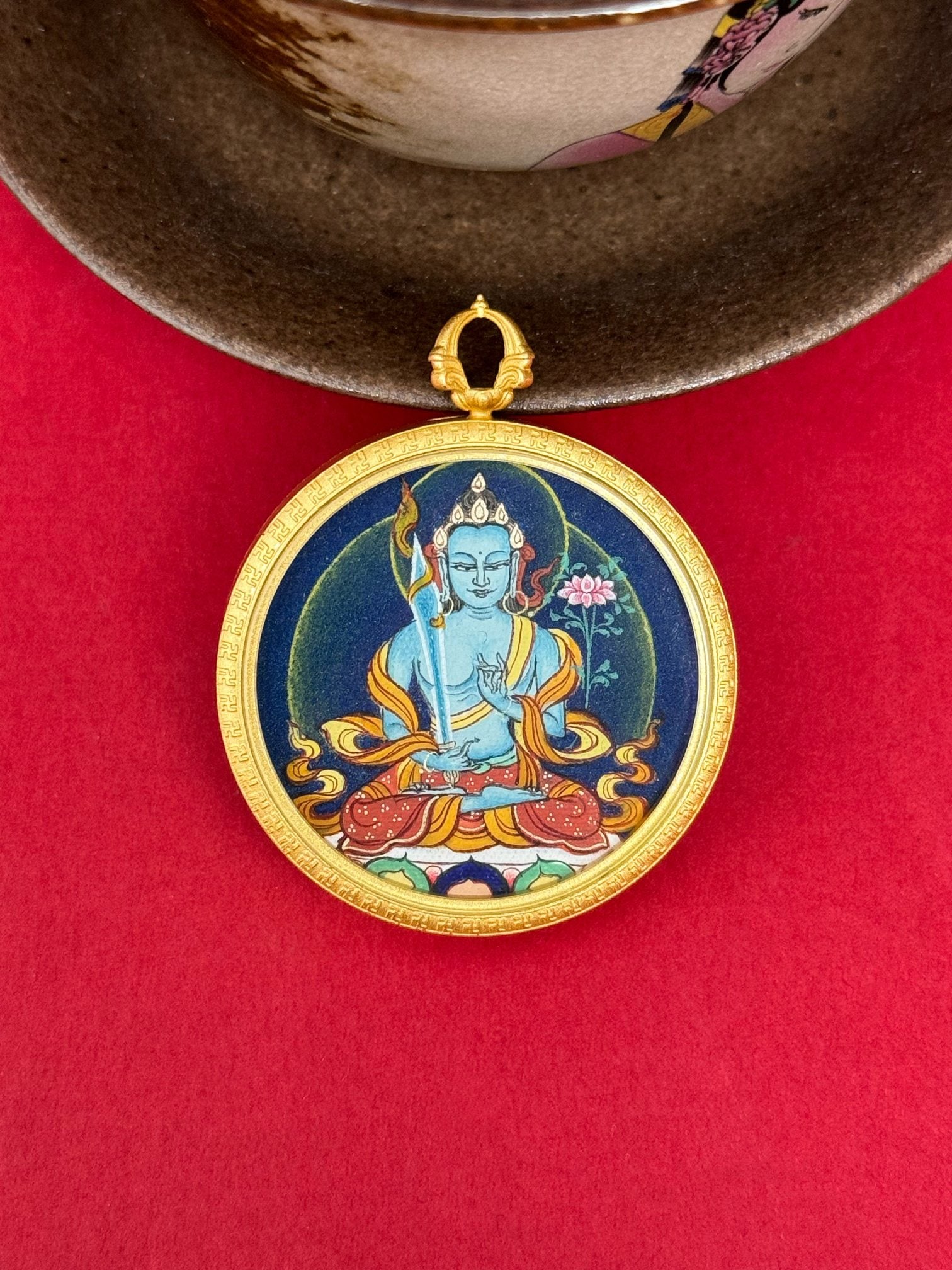  The Tibet Bold Akasagarbha Thangka pendant with copper casing displayed as a sacred amulet for wisdom and wealth, embodying Buddhist tradition.

