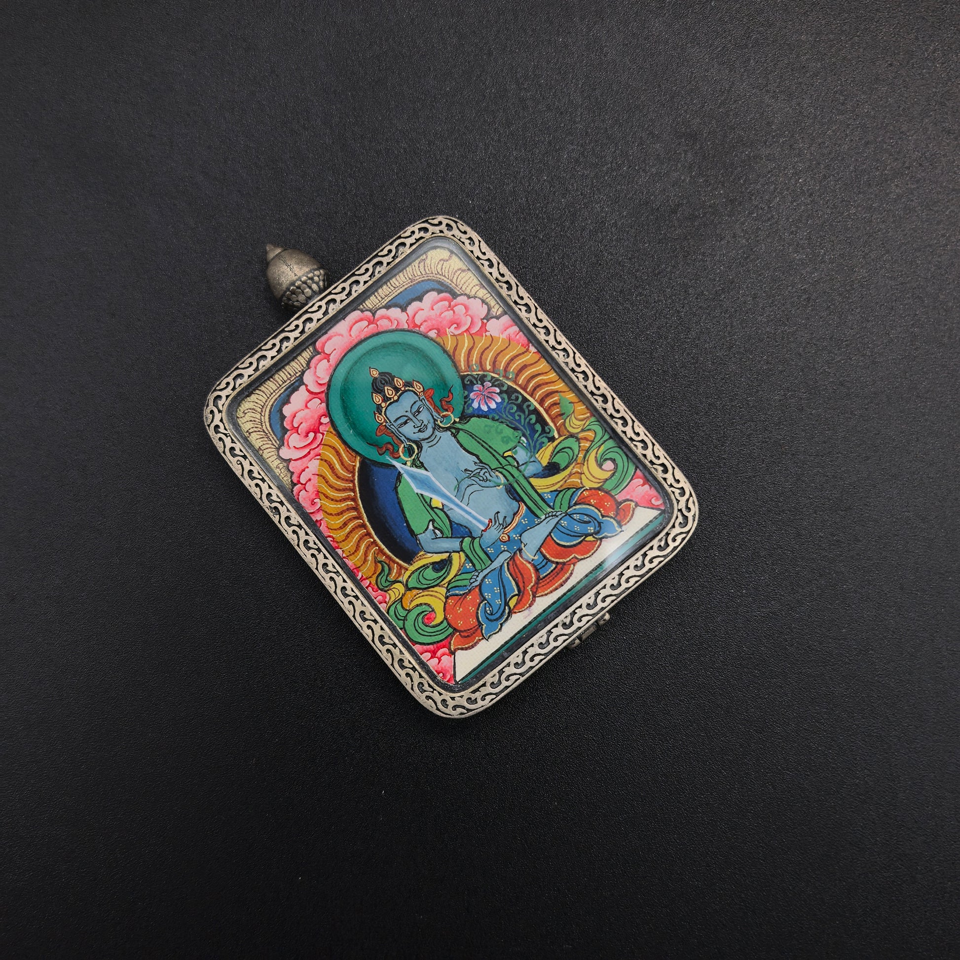 The Tibet Red Cloud Akasagarbha Thangka pendant with 925 silver displayed as a sacred amulet for wealth and fortune, embodying Buddhist tradition.

