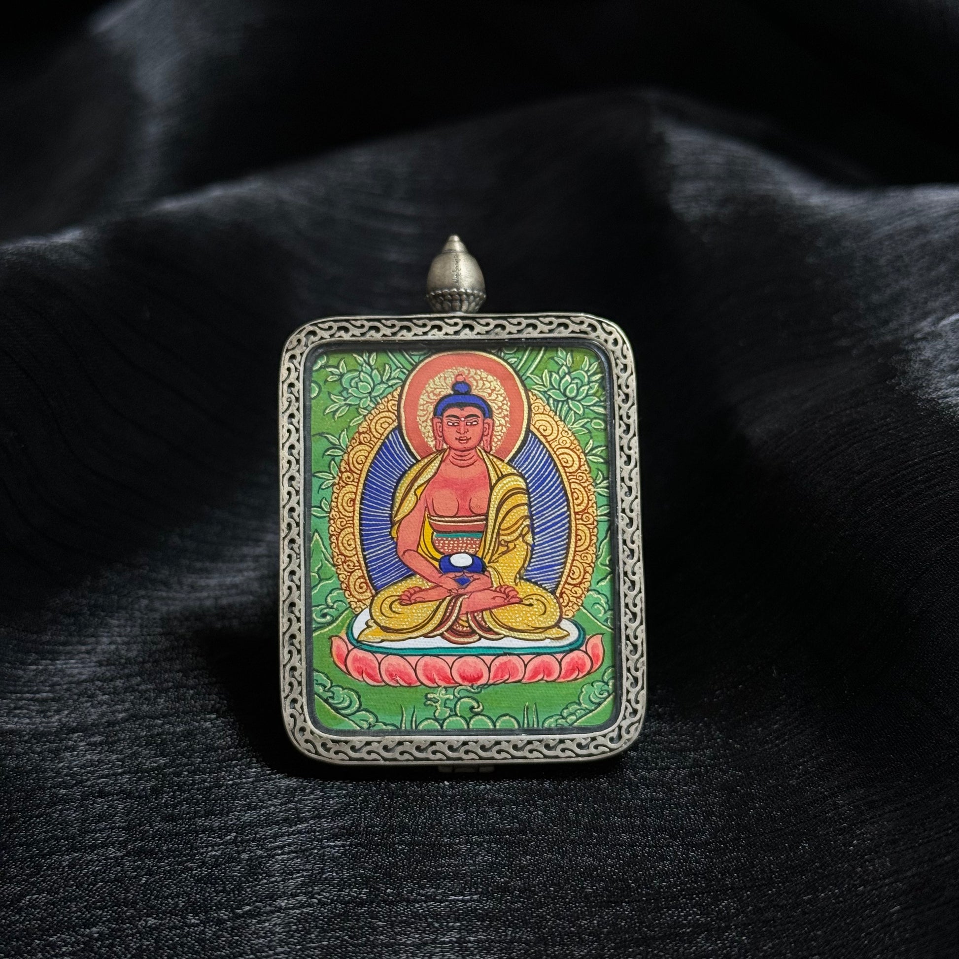  Detailed view of the presentation and casing for the Amitabha Cuiying Thangka pendant, symbolising protection and tradition in Buddhist practice.

