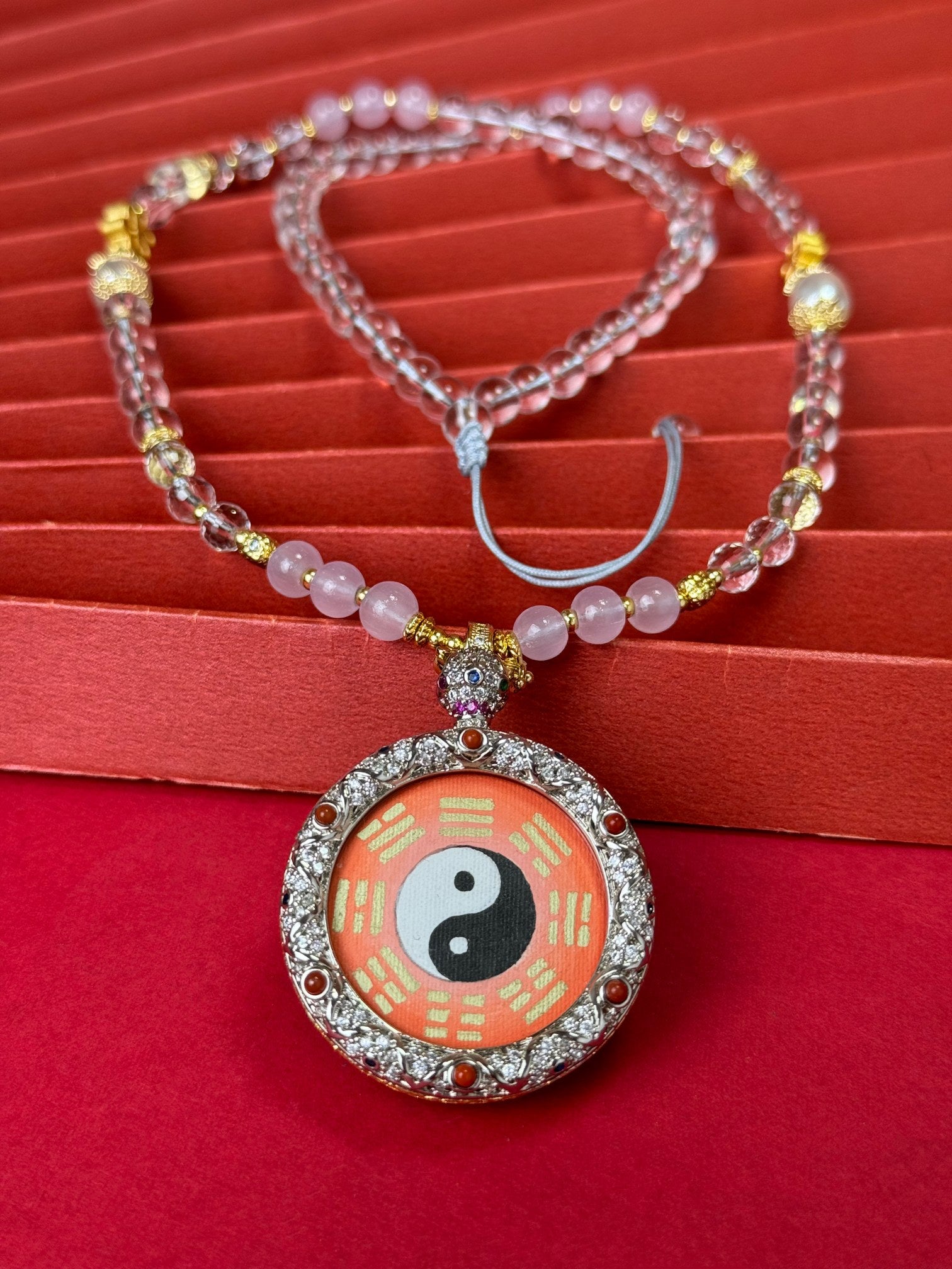  The Rekong Red Gold Amitabha Thangka pendant with copper casing displayed as a sacred amulet for transcendent wisdom and life smooth throughout, embodying Buddhist tradition.

