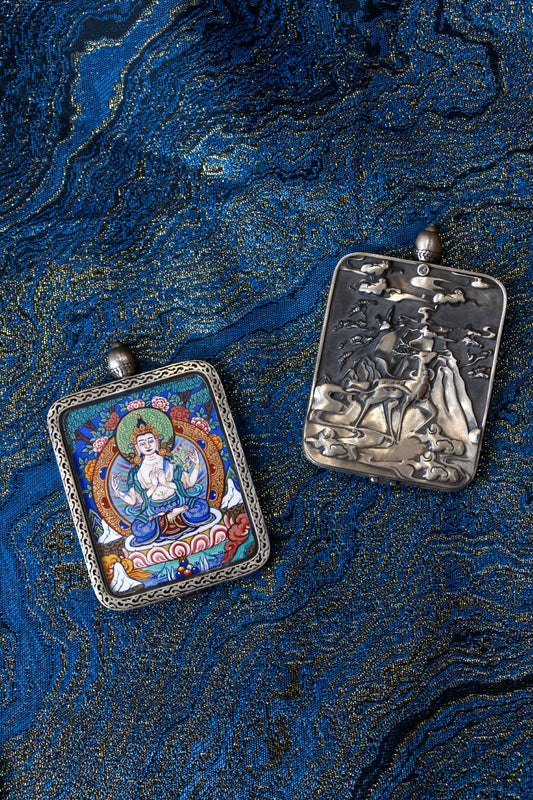 Close-up of the S925 sterling silver case with Dunhuang Nine-Colored Deer engraving, protecting the Four-Armed Avalokiteshvara Thangka.