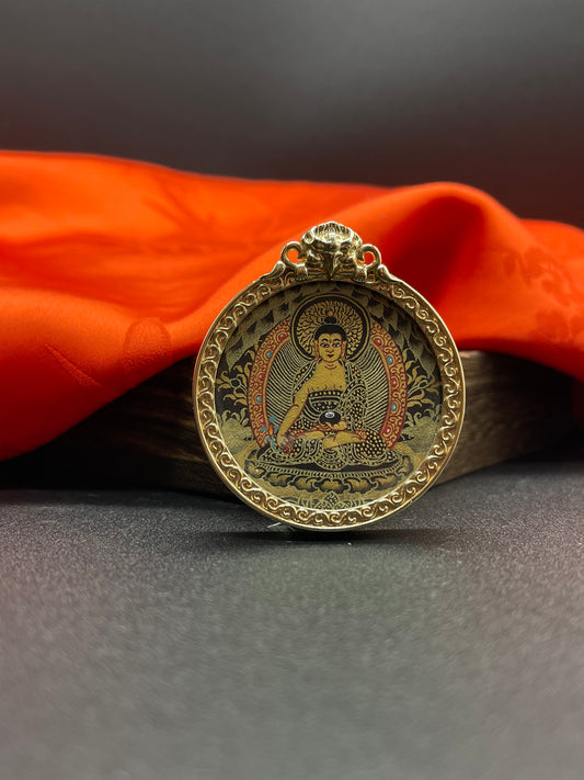  A 3.5cm hand-painted Rekong Black Gold Bhaisajyaguru (药师佛) Thangka pendant with copper casing featuring the Medicine Buddha, lord of the Eastern Lapis Lazuli Pure Land, representing healing and longevity in Buddhist tradition.
