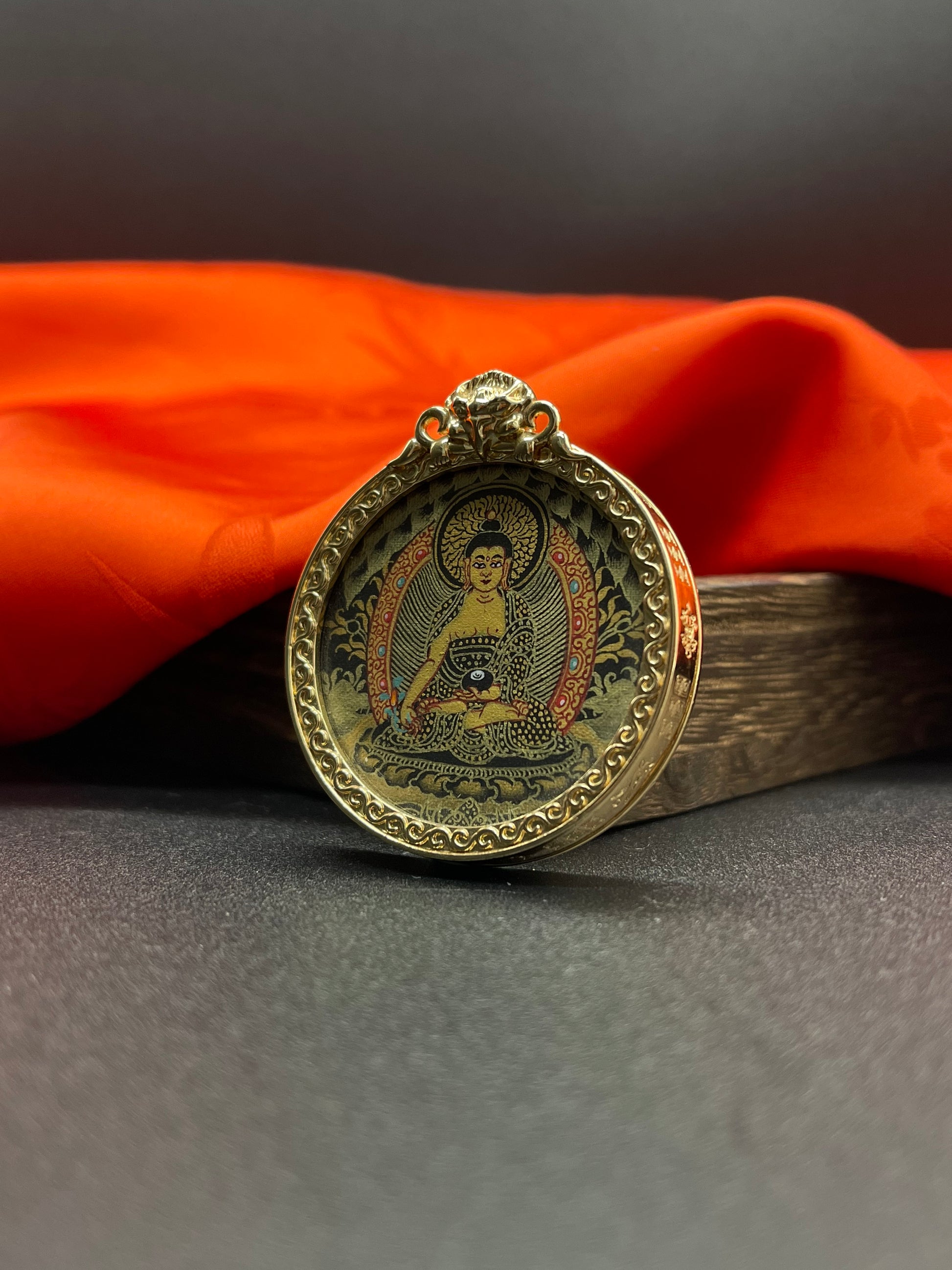  The Rekong Black Gold Bhaisajyaguru pendant with copper casing displayed as a sacred amulet for healing and longevity, embodying Buddhist tradition.

