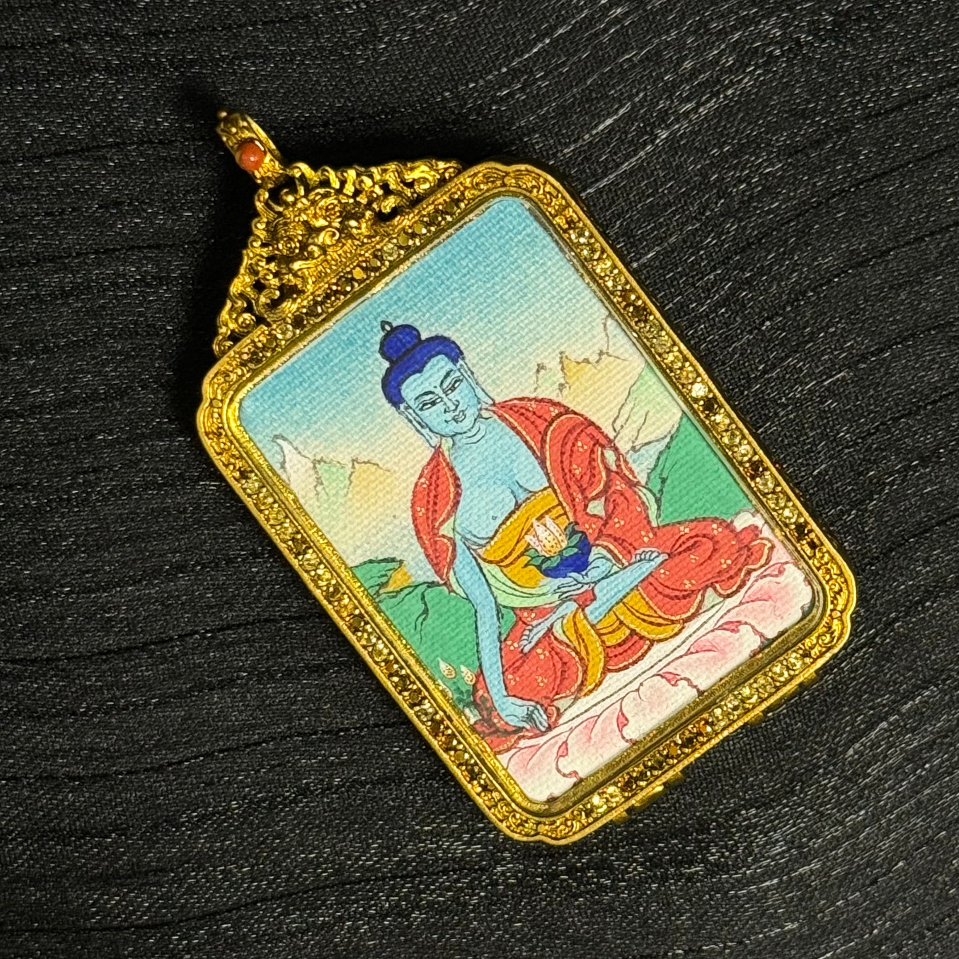 The Tibet Bhaisajyaguru Thangka pendant displayed as a sacred amulet for healing and peace, embodying Buddhist tradition.
