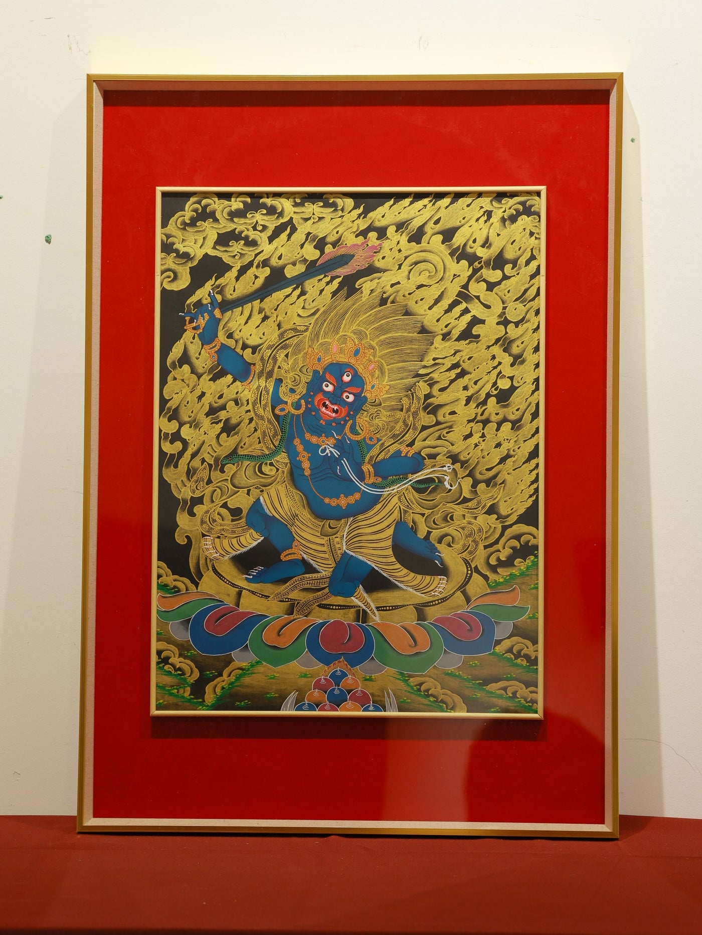 A Thangka painting of Acala Mahakala as a fierce protector in a striking black and gold color scheme, featuring intricate details.