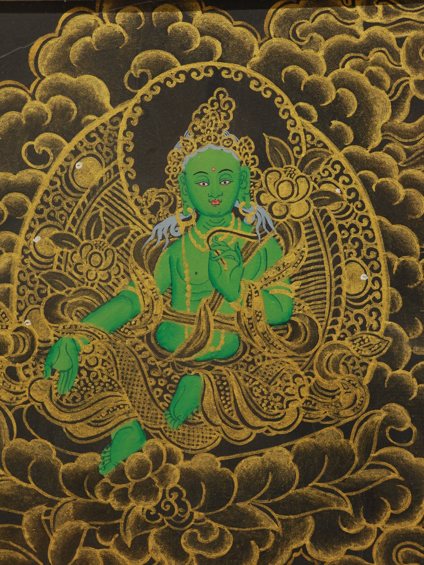 Traditional Tibetan Buddhist painting of black and gold Manjushri Bodhisattva, symbolizing wisdom and knowledge.