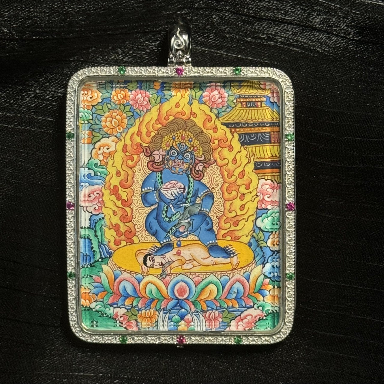  The Black Jambhala with Mandala Thangka pendant displayed as a sacred amulet for swift wealth blessing and protection, embodying Tibetan Buddhist tradition.
