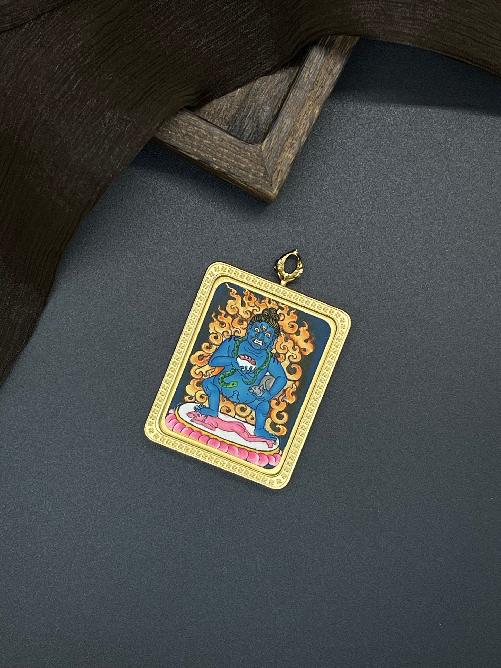 Hand-painted Nepal Black Jambhala (黑财神) Thangka pendant 3.5x4.5cm with titanium casing featuring the chief of side wealth, representing the flow of prosperity in Buddhist tradition.
