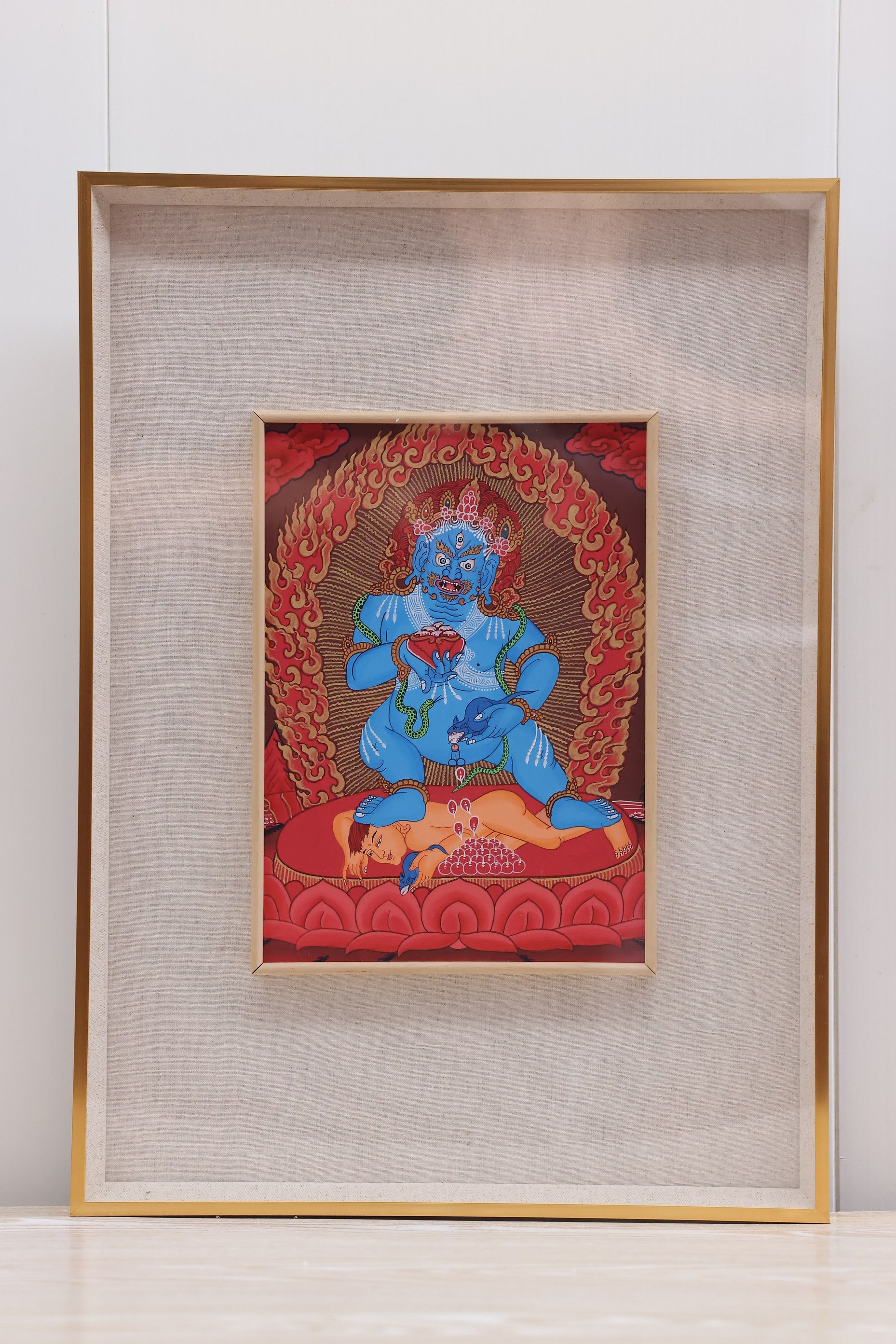 Traditional Tibetan Buddhist red thangka painting of Black Jambhala, revered as a powerful wealth and prosperity deity