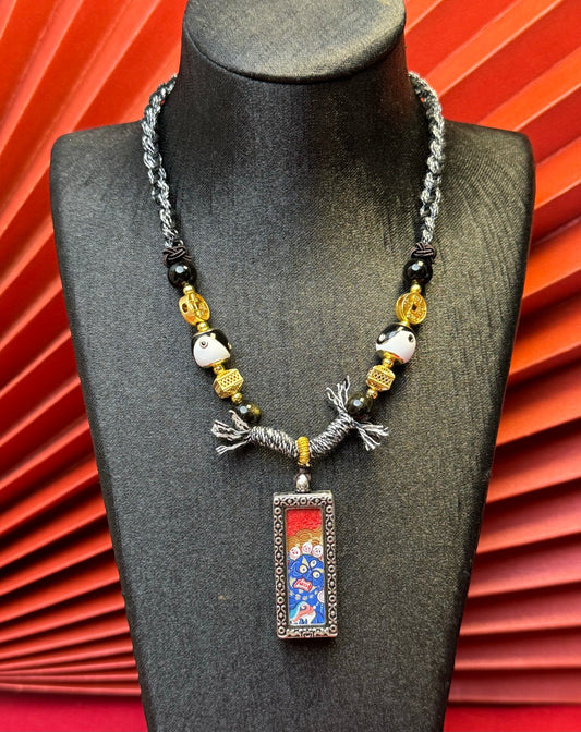 Close-up detail of the Rekong Black Jambhala Thangka showing hand-painted mineral pigments and cinnabar, showcasing the masterful artistry and rich texture.