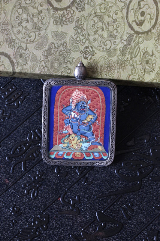 Tibetan thangka amulet featuring Black Jambhala, revered in Tibetan Buddhism for attracting wealth and removing poverty.