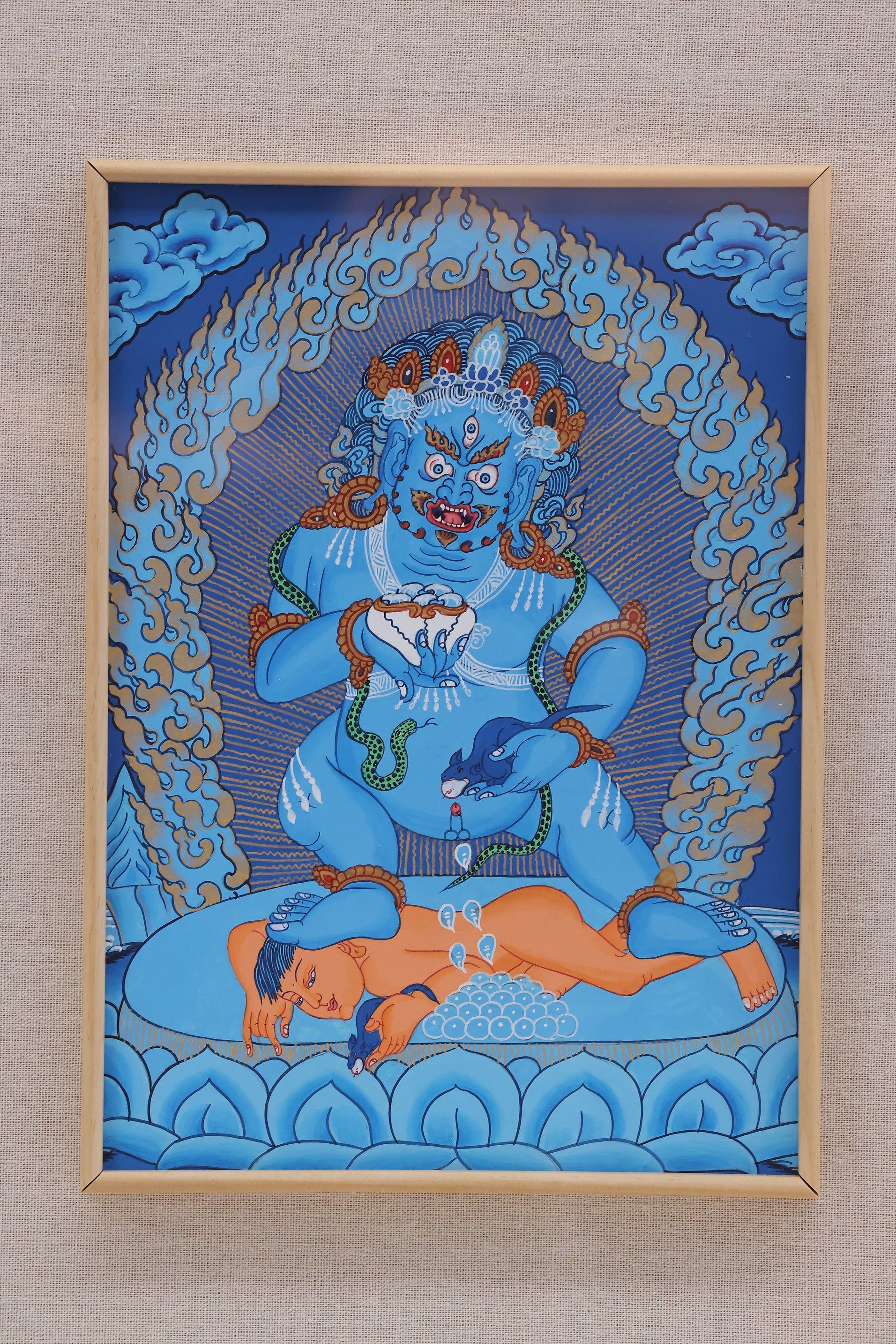 Traditional Tibetan blue background thangka painting of Black Mahakala, a protector deity associated with wealth.