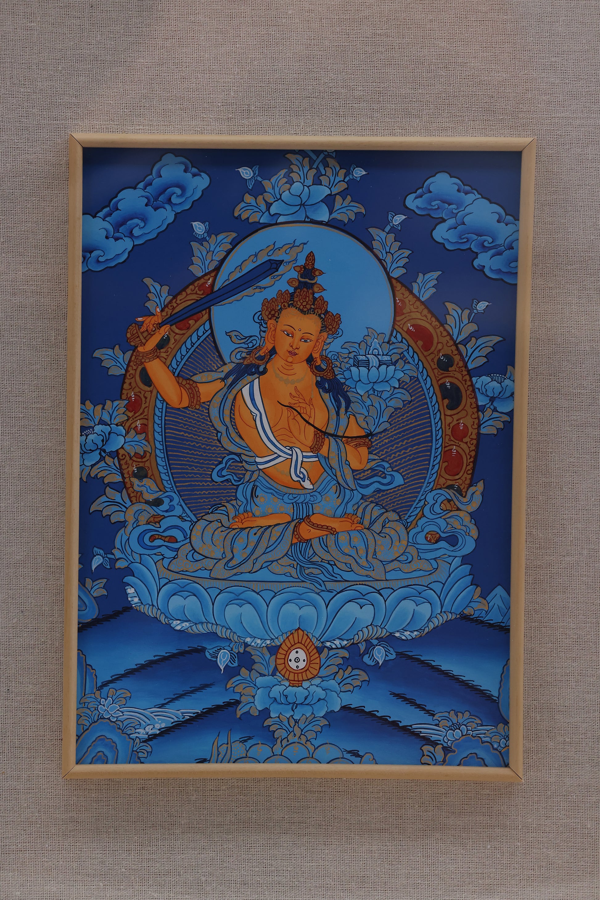 Sacred blue thangka painting of Manjushri, symbolizing transcendent wisdom in Tibetan Buddhism.
