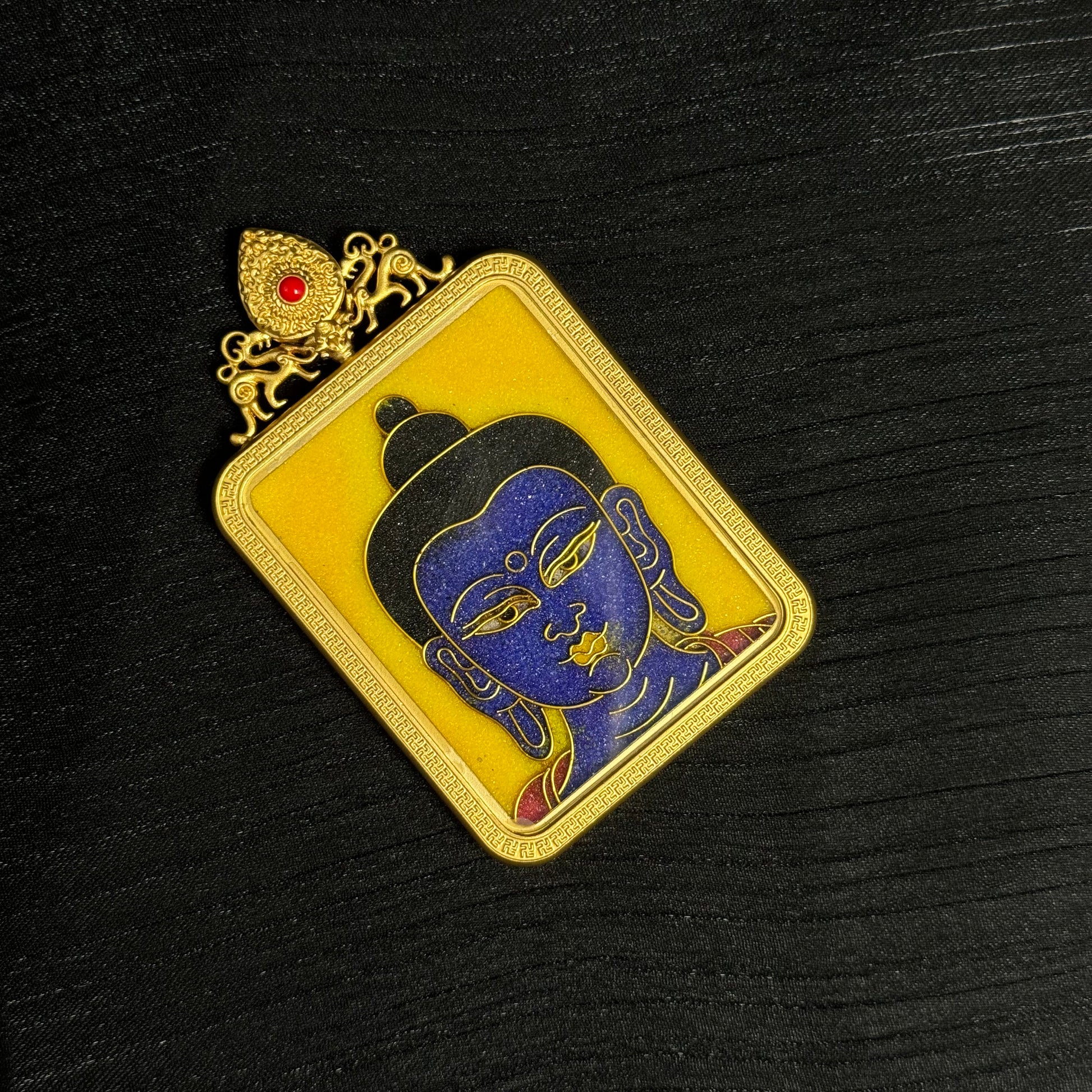 The cloisonné Bhaisajyaguru Thangka pendant displayed as a sacred amulet for healing and longevity.

