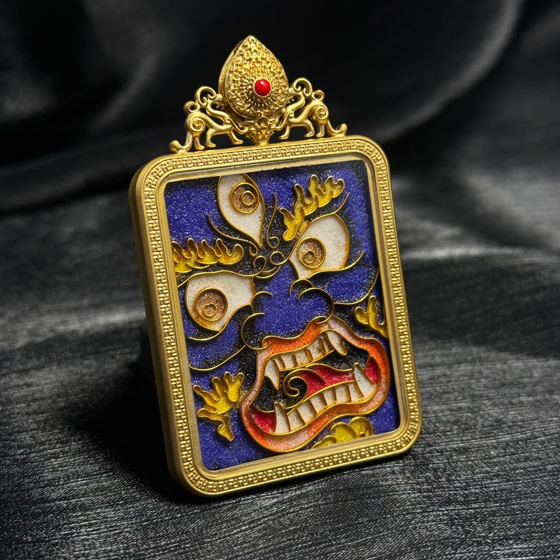  A 4x5cm cloisonné Six-Armed Mahakala Thangka pendant with copper 24K gold-plated casing, representing protection and fortune in Buddhist tradition.
