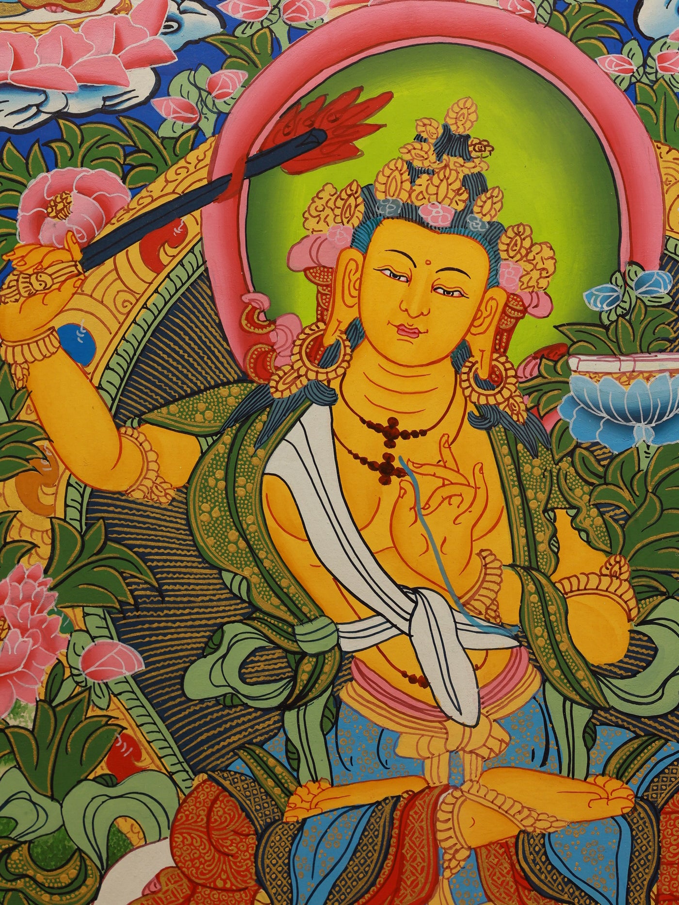 Manjushri thangka with intricate ornamentation, cloud motifs, and prayer flags, reflecting traditional Tibetan Buddhist iconography.