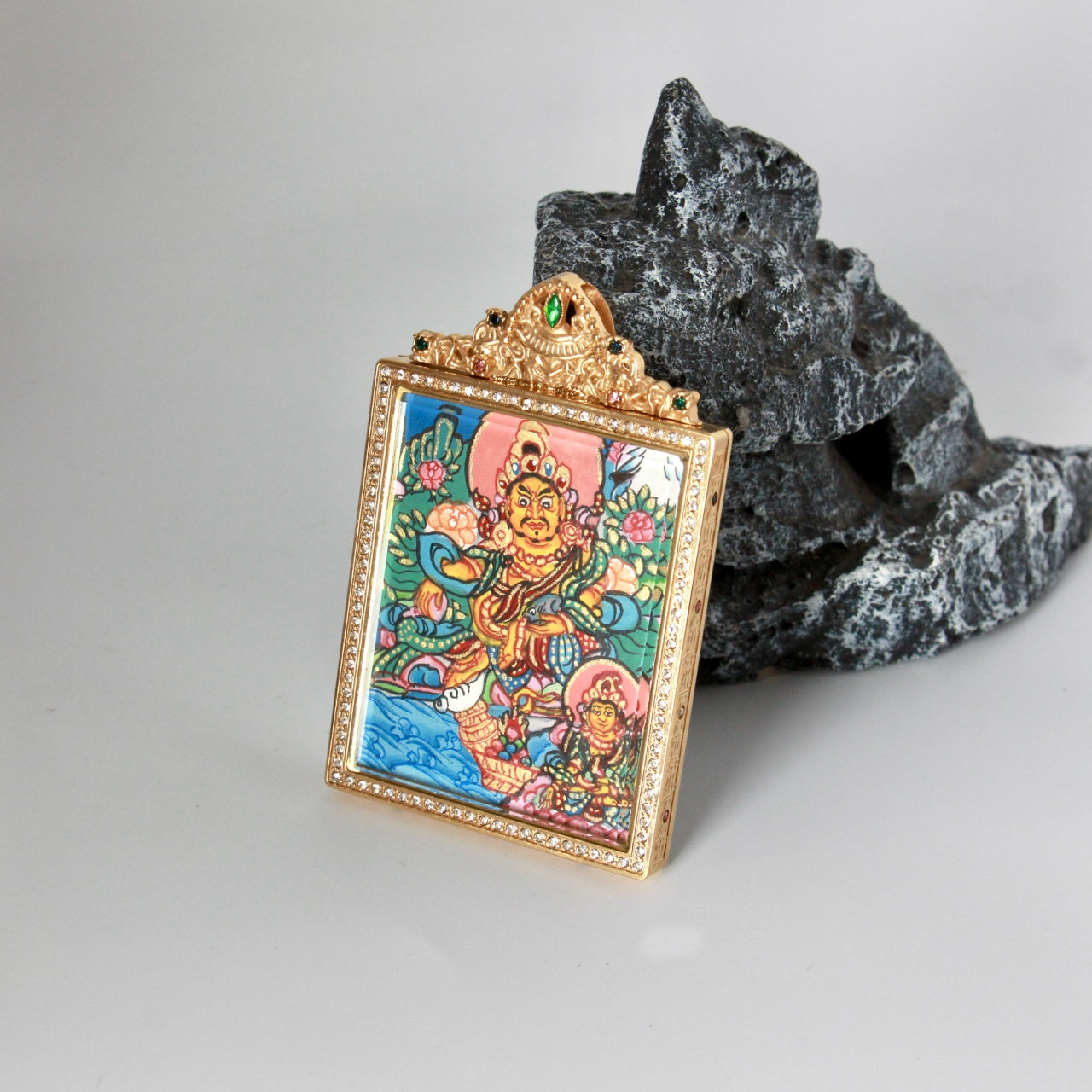 The Nepal Dual Jambhala and Vasudhara Thangka pendant displayed as a sacred amulet for wealth and merit, embodying Tibetan Buddhist tradition.

