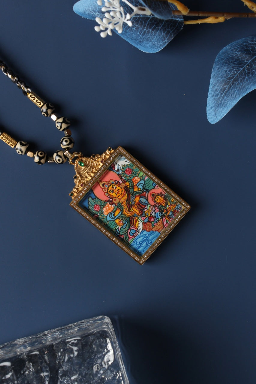 A 3.5x4.5cm hand-painted Tibetan Buddhist Dual Yellow Jambhala Thangka pendant featuring the twin wealth-bestowing deities, encased in exclusive 925 Sterling Silver, representing prosperity and abundance in Tibetan Buddhist culture.

