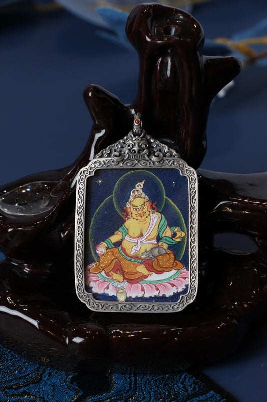 Dzambhala yellow thangka pendant representing wealth, good fortune, and compassionate generosity in Tibetan Buddhism.