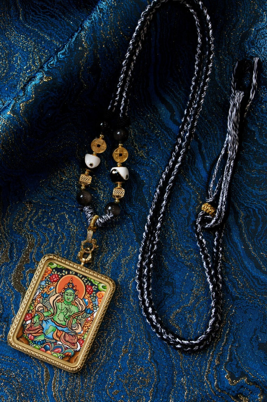 A beautifully crafted pendant featuring a Green Tara Thangka design in vibrant emerald, symbolizing joy and protection in Tibetan Buddhist culture.