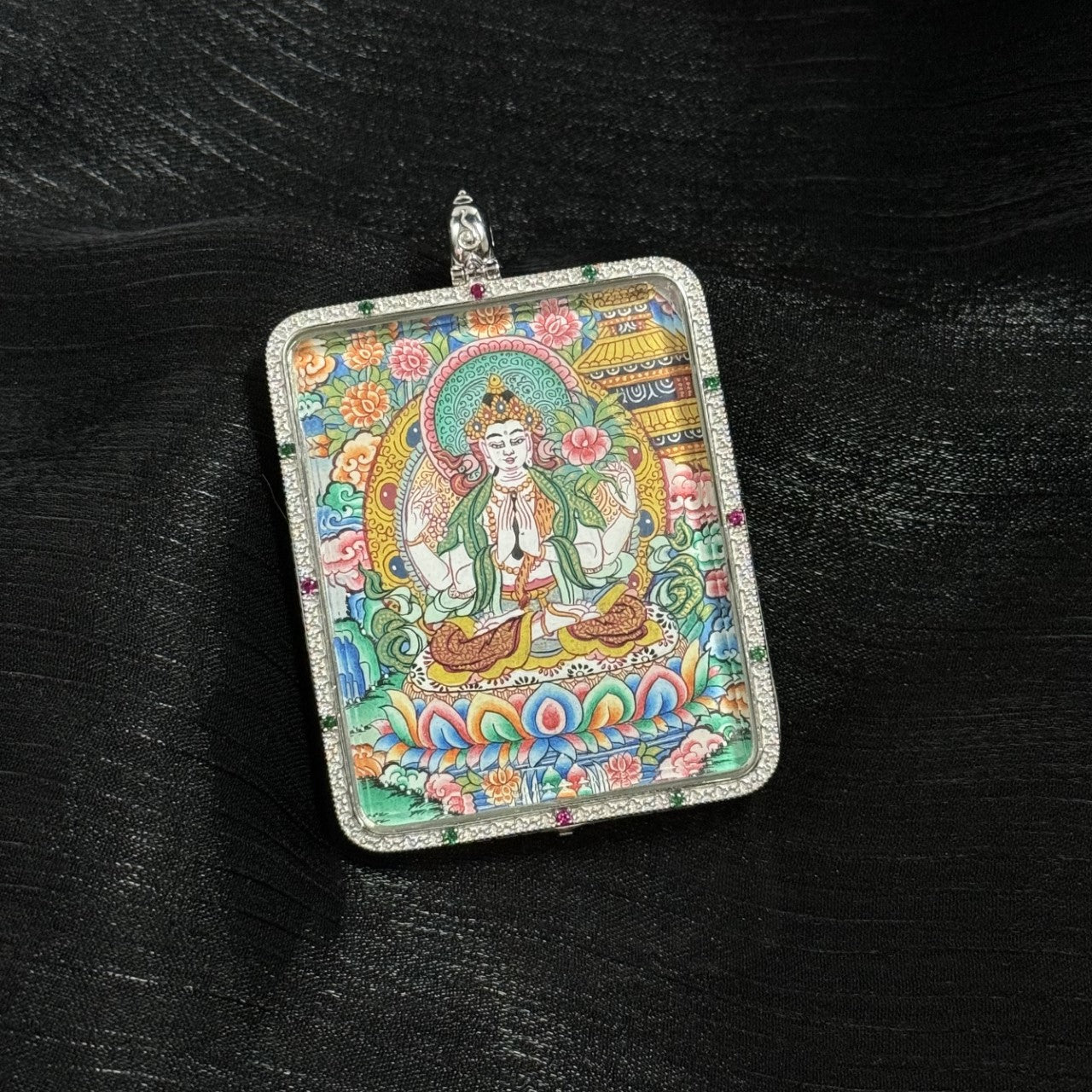  The Four-Armed Avalokiteshvara with Eight Guardians and Mandala Thangka pendant displayed as a sacred amulet for compassion and family, embodying Tibetan Buddhist tradition.
