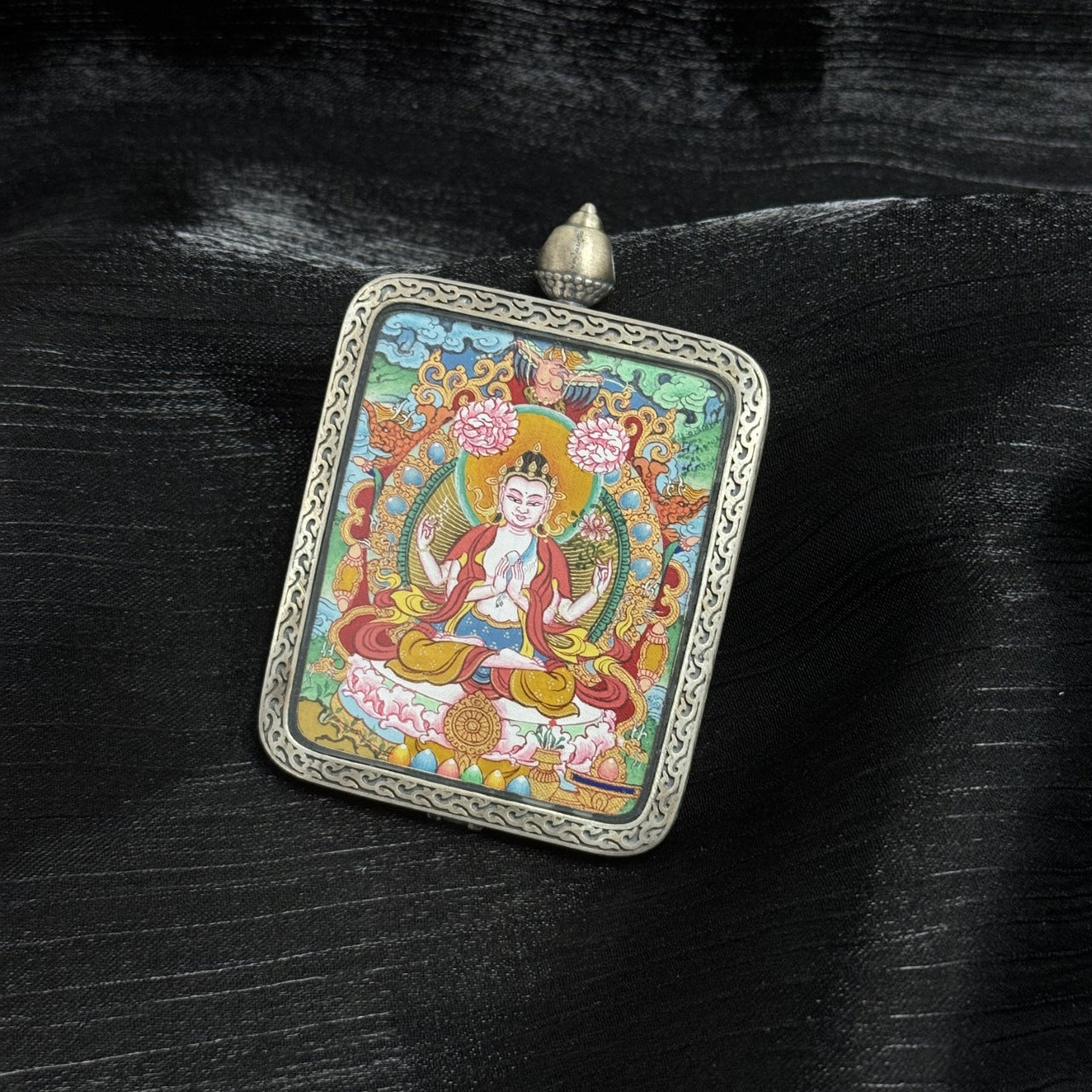  Close-up detail of the Menri Four-Armed Avalokiteshvara Thangka painting showing intricate natural mineral pigment work and symbolic attributes, showcasing the artistry of Tibetan lineage painters.
