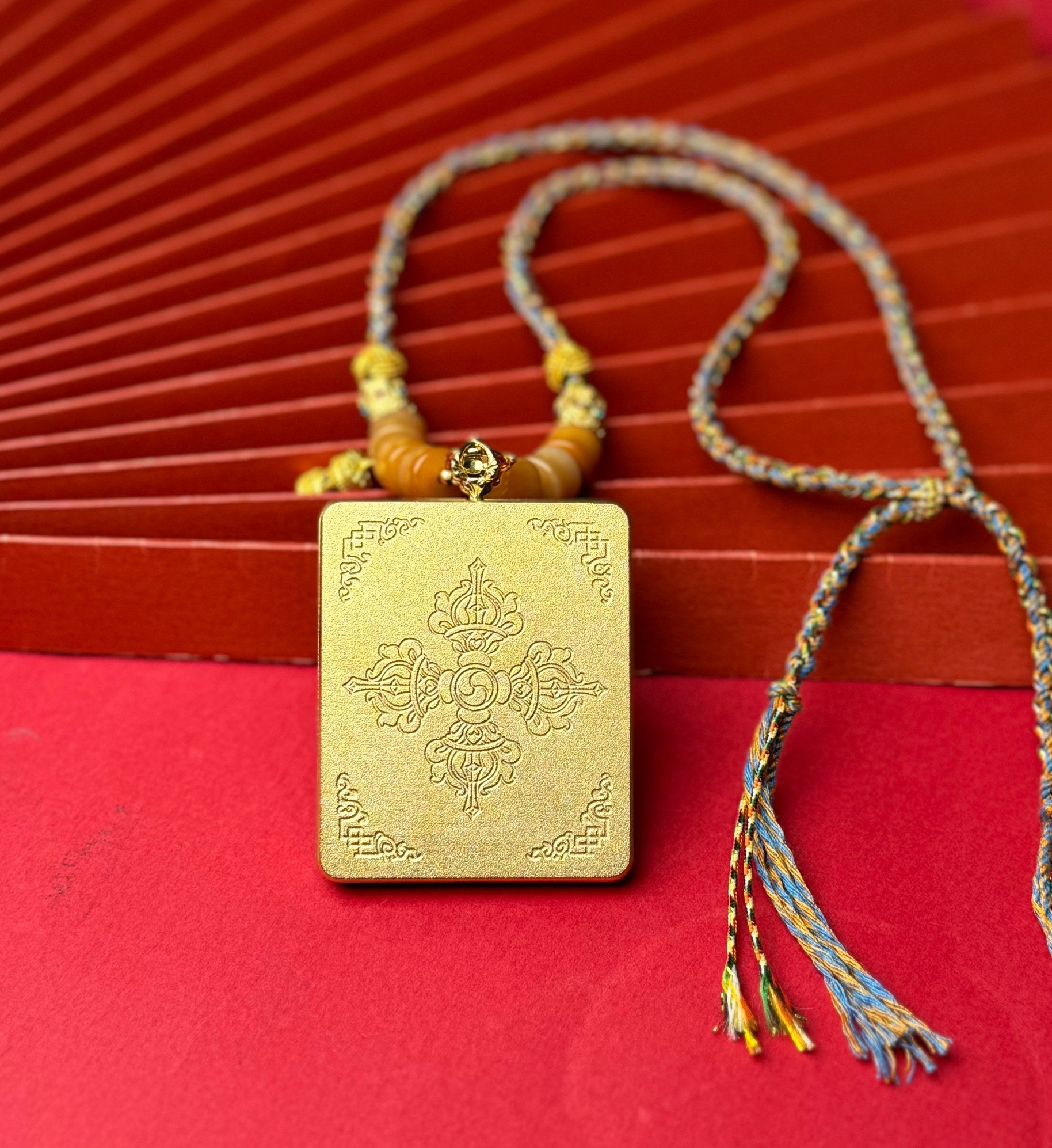  The Nepal Four-Armed Avalokiteshvara Thangka pendant with titanium casing displayed as a sacred amulet for compassion, health and wealth, embodying Buddhist tradition.

